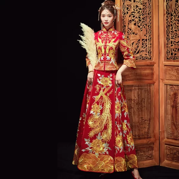 The bride in MIRACLANDS' sumptuous qun kwa wedding dress, featuring phoenixes and peonies on the blouse and skirt, embodies prosperity, good fortune, and a happy marriage. This Chinese cheongsam wedding dress combines the elegance of a long cheongsam with exquisite hand embroidery, showcasing beautifully detailed dragon and phoenix motifs on the front of the bodice. The classic red color and three-dimensional cut add a touch of vintage elegance, making it an ideal traditional Chinese wedding dress. As a stunning Chinese wedding gown and Chinese bridal dress, it is perfect for a Chinese tea ceremony dress, reflecting the timeless beauty found in a bridal Chinese cheongsam. Available at any reputable Chinese clothing shop, this ensemble exudes both cultural significance and sophisticated style.