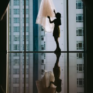women's white gown hanged on clear glass window